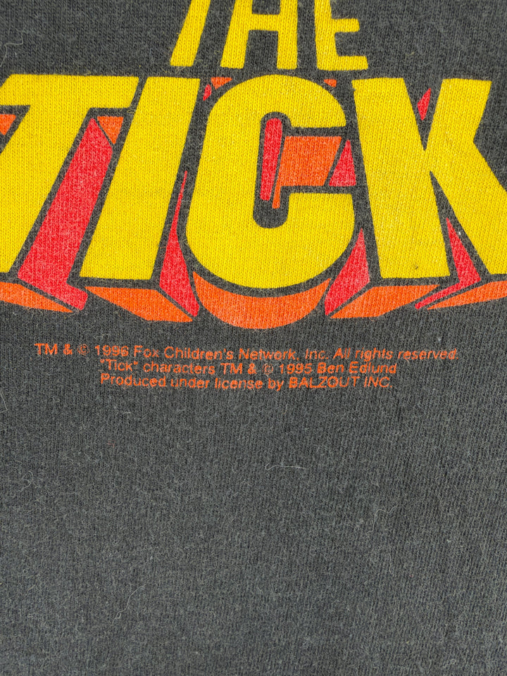 Exile Vintage 1990s The Tick graphic t-shirt featuring yellow and orange logo print on black cotton fabric