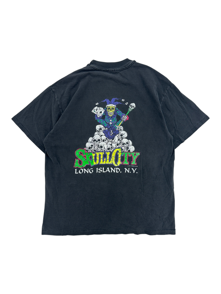Exile Vintage 1990s black Skull City graphic t-shirt featuring a jester on a pile of skulls, back view