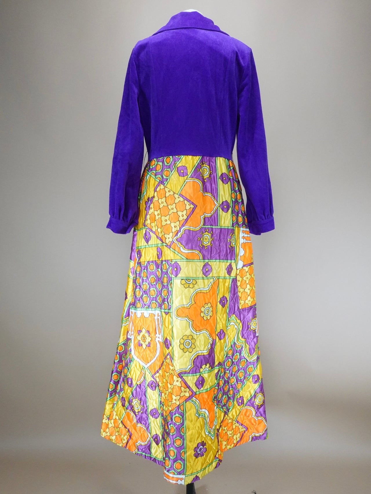 Mannequin wearing a purple top and colorful floral dress against a neutral background