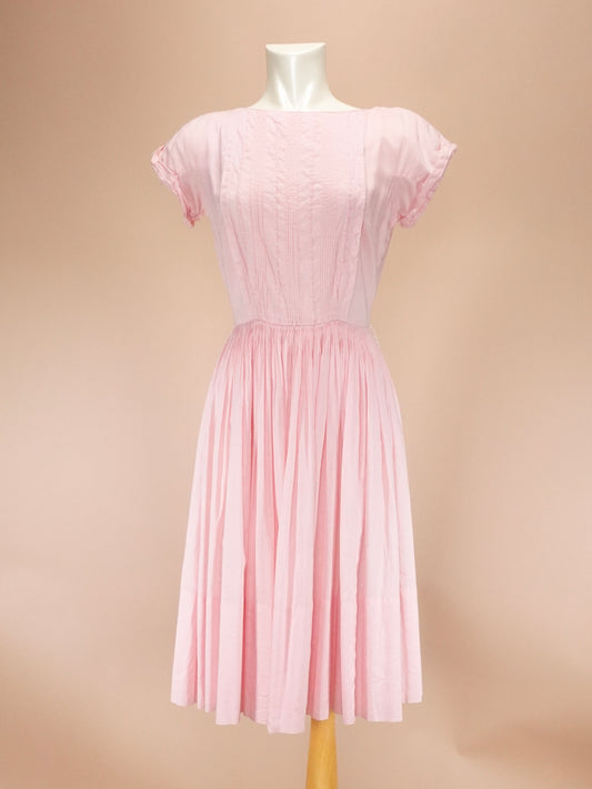 Pink dress on a mannequin against a beige background