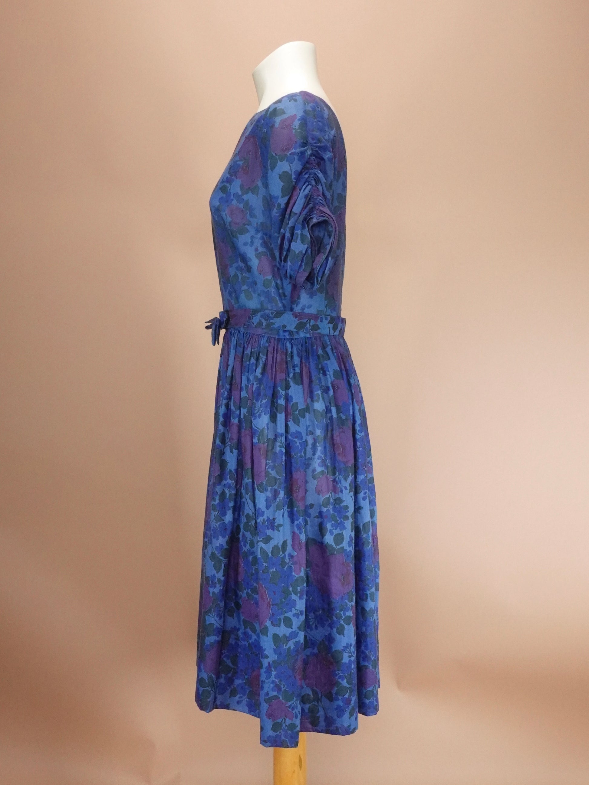 Blue floral dress on a mannequin against a beige background