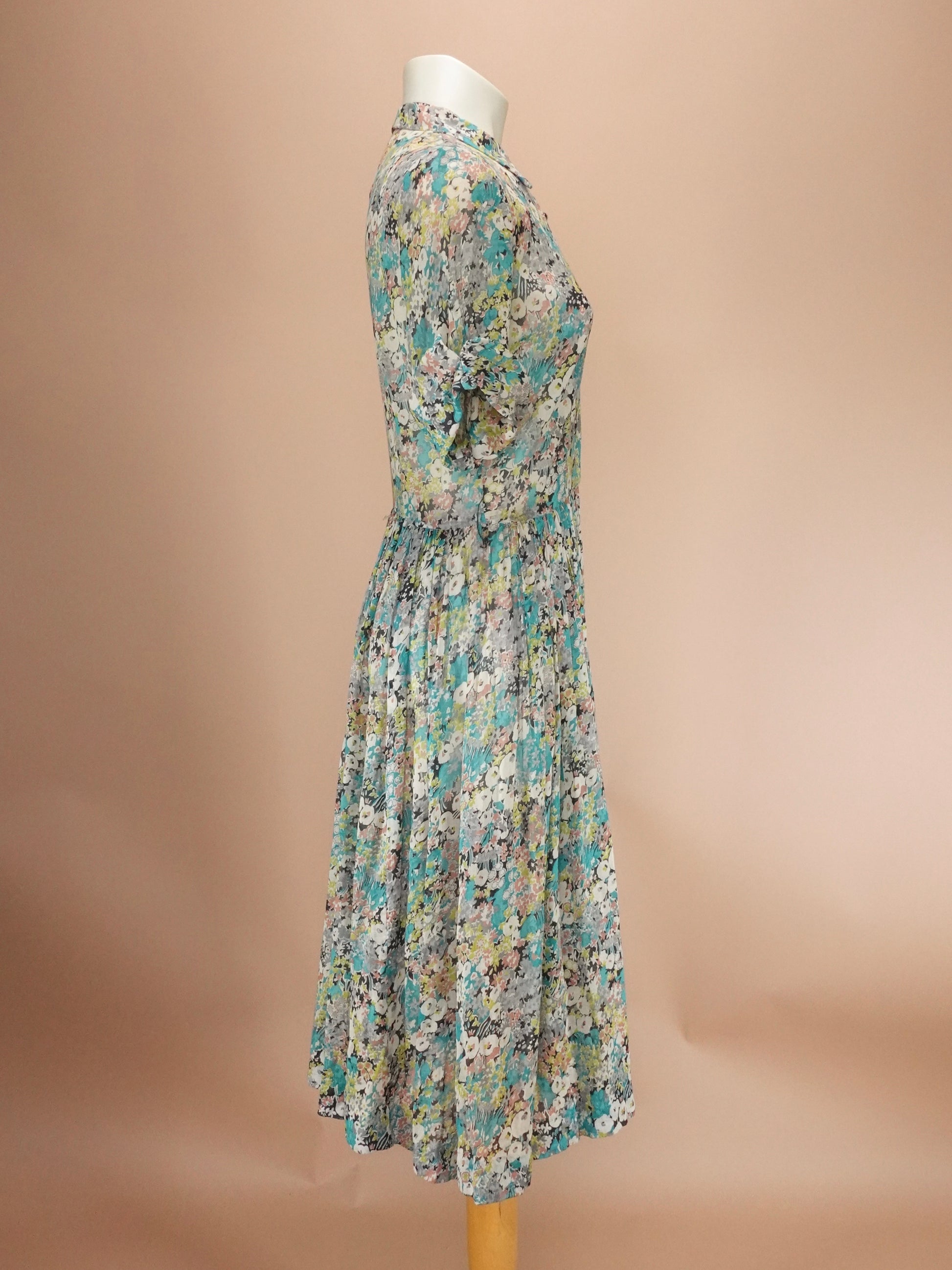 Floral dress on a mannequin against a beige background