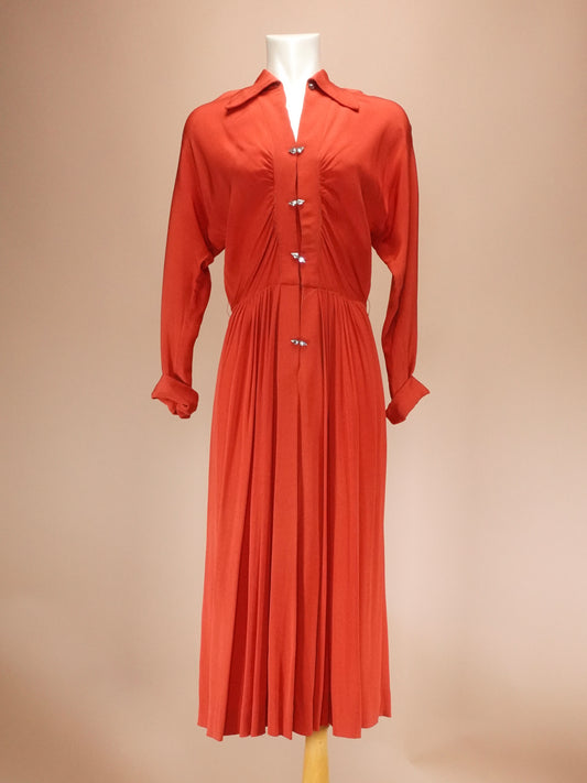 Orange dress on a mannequin against a beige background