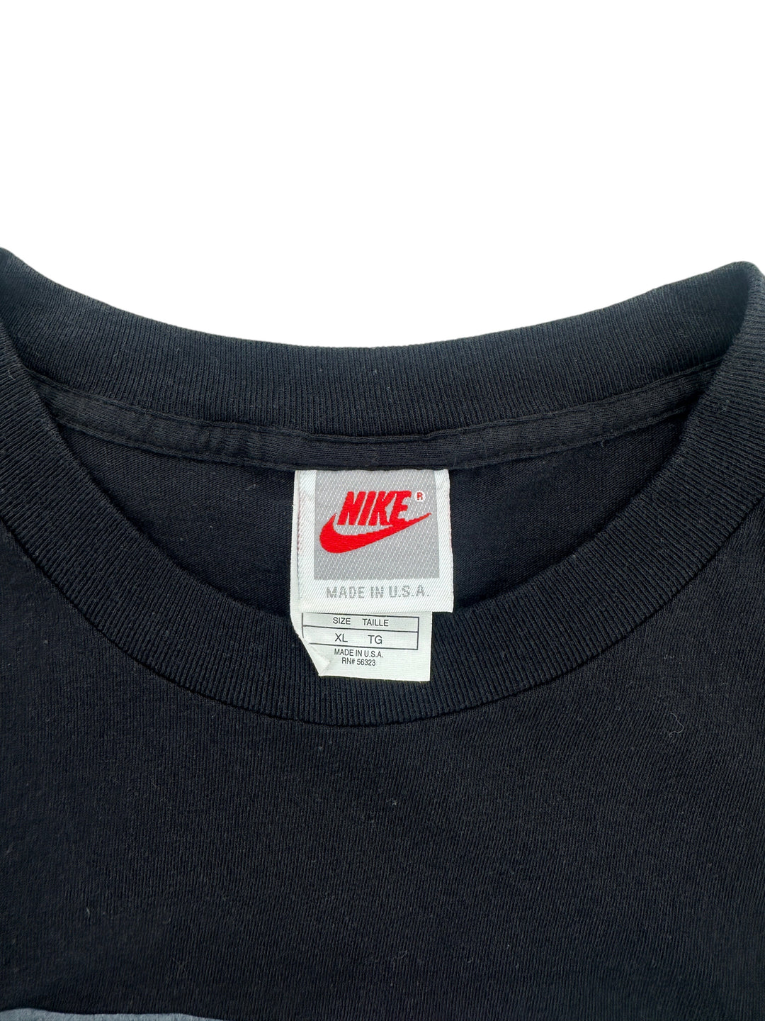 Exile Vintage 1990s Nike P.L.A.Y black t-shirt neck label showing size XL and Made in U.S.A. tag