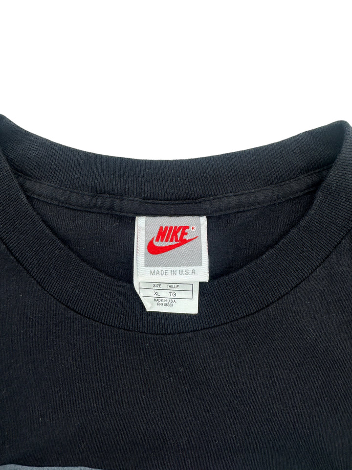 Exile Vintage 1990s Nike P.L.A.Y black t-shirt neck label showing size XL and Made in U.S.A. tag